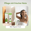 Frau in der Dusche trägt Aloe-Jojoba Shampoo auf