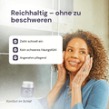 Frau lächelt und streicht sich durch das Gesicht + Forever Restoring Creme